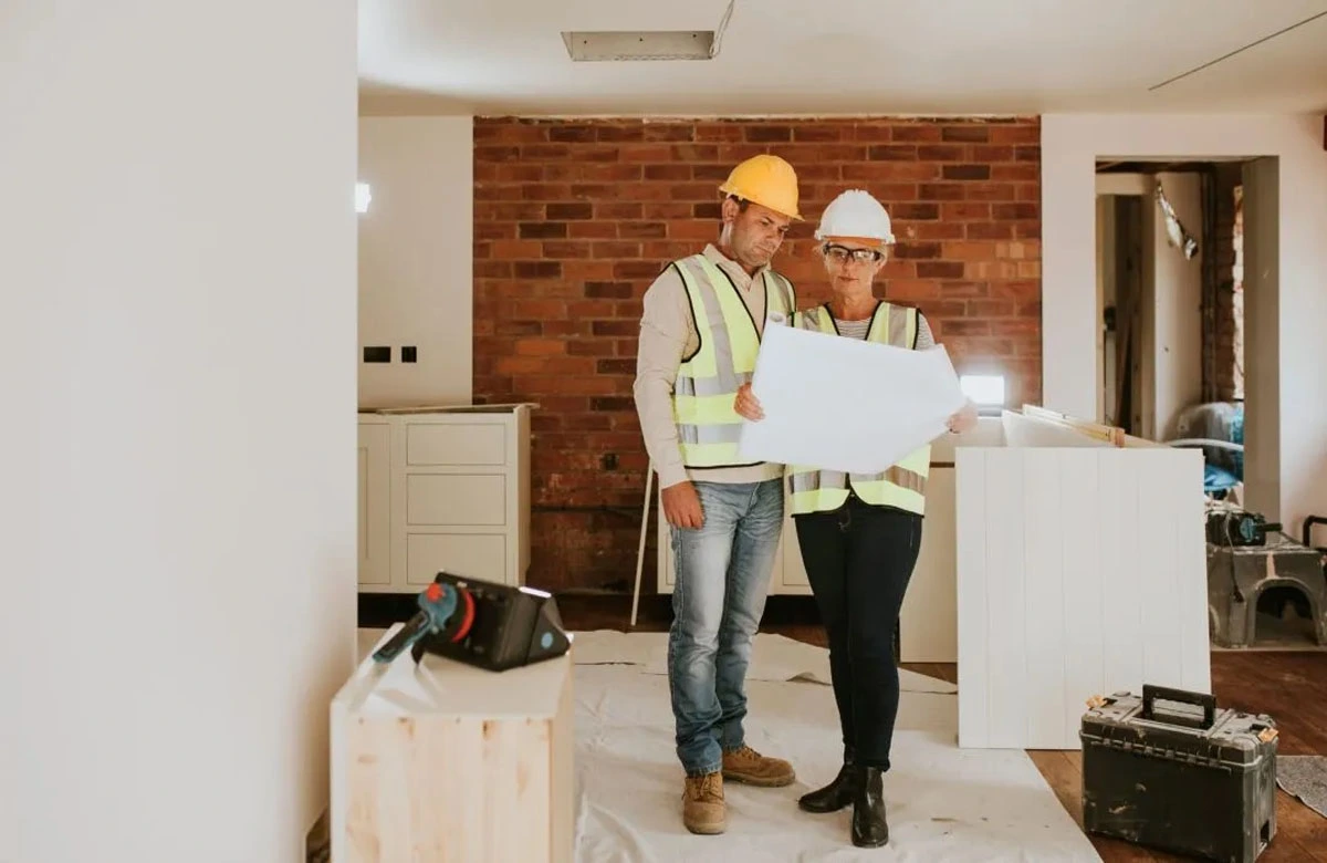 Experienced Austin remodeling contractors reviewing interior blueprints for kitchen and living area upgrades during active project execution.