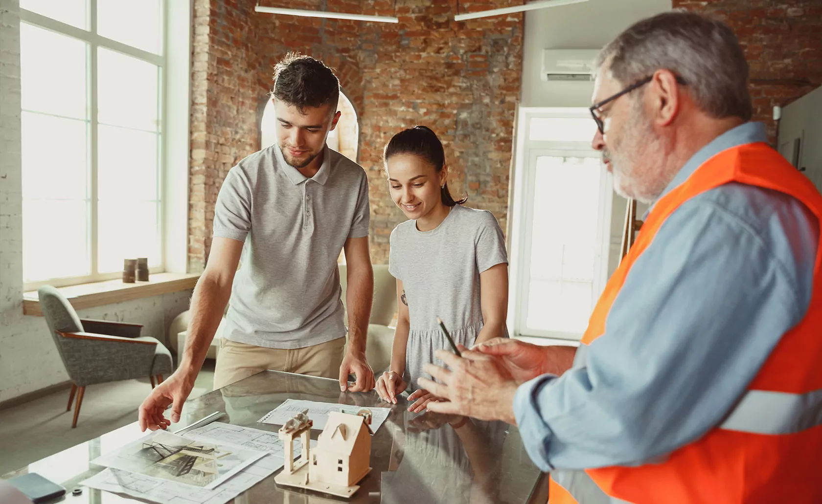Homeowner consulting with a contractor over blueprints for a home renovation project.