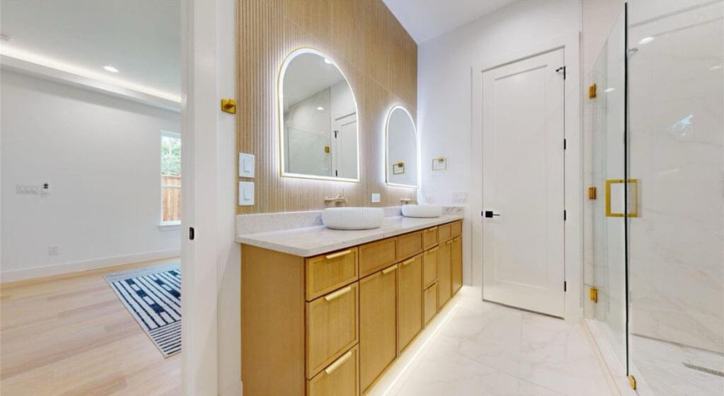 Twin sink vanity with wood cabinetry and LED mirrors