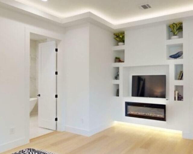 Bedroom with recessed shelf wall and built-in fireplace remodel